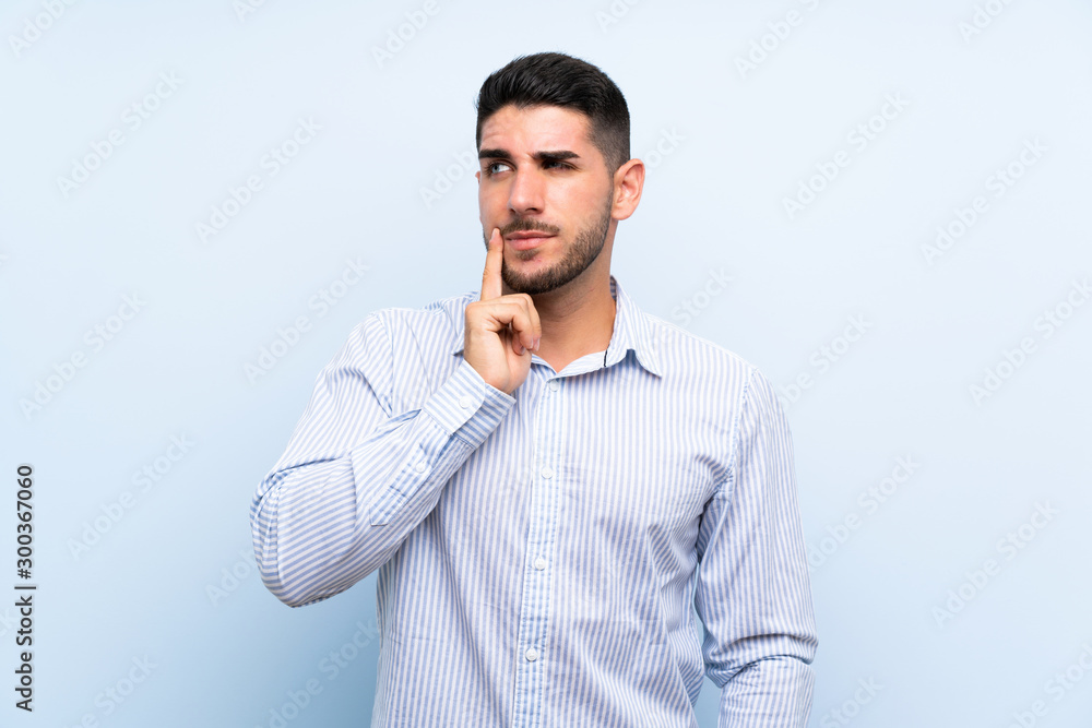 Caucasian handsome man over isolated blue background thinking an idea Caucasian handsome man over isolated blue background thinking an idea