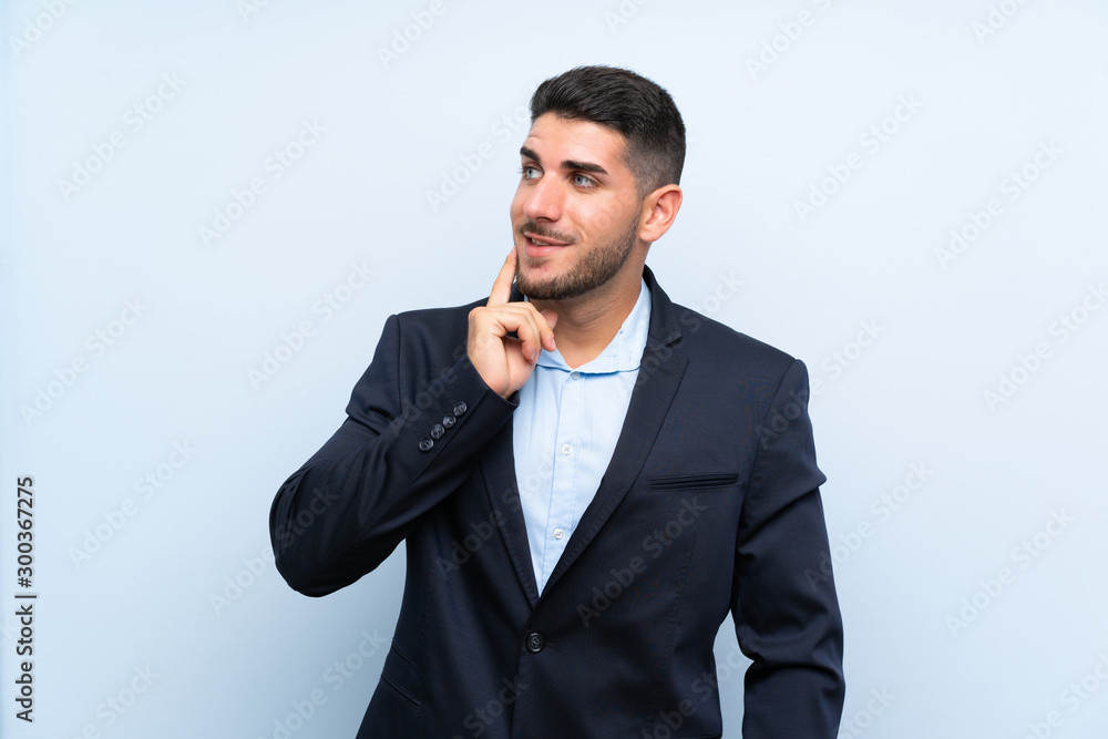 Handsome man over isolated blue background thinking an idea while looking up Handsome man over isolated blue background thinking an idea while looking up