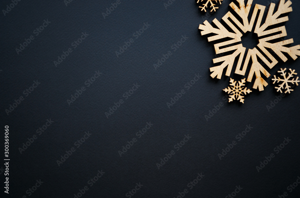 Christmas and New Year background. Hand made rustic wooden snow flakes on black backdrop for winter holidays wallpaper. Empty space for text on poster. Handmade crafts for holiday decor - obrazy, fototapety, plakaty 