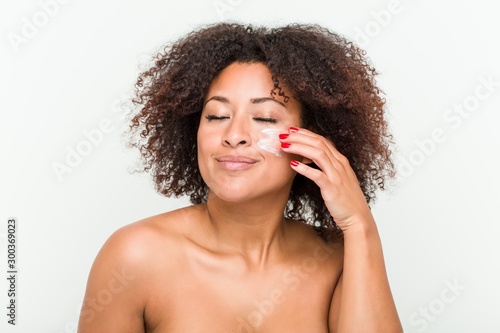 Close up of a young african american woman applying a moisturizing cream