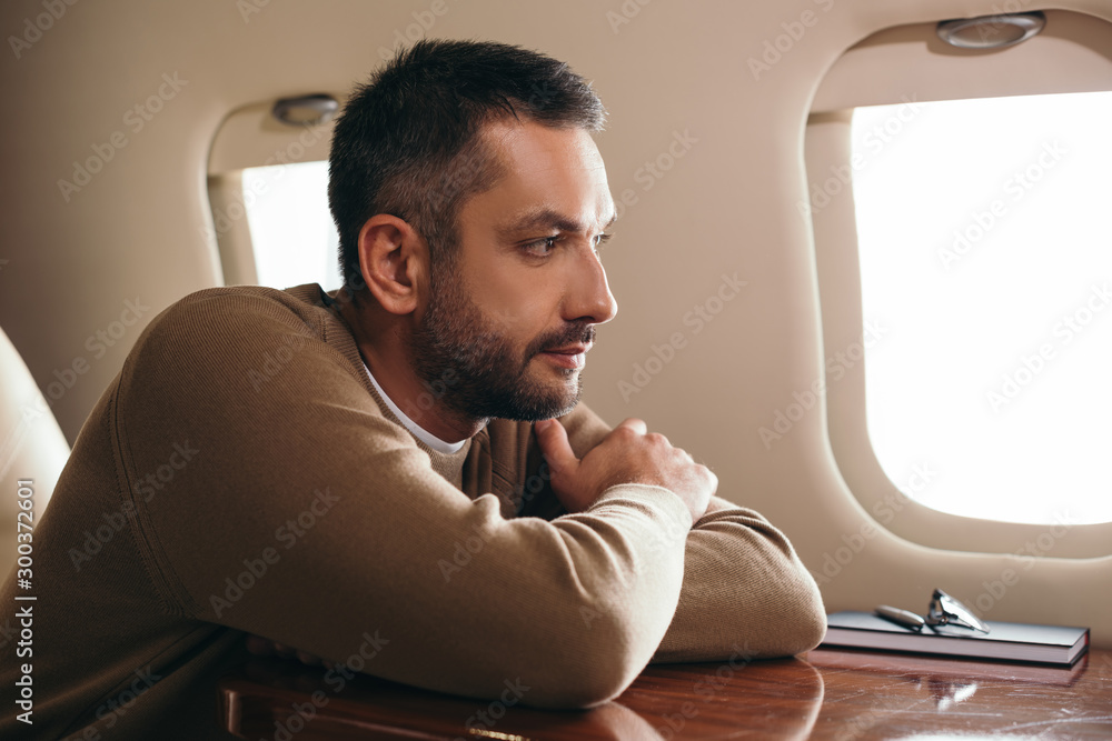 handsome bearded man sitting in first class of private jet