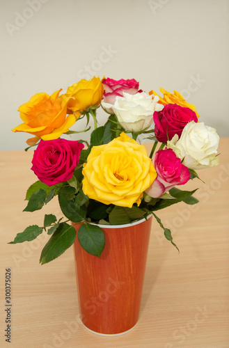 bouquet of roses in a plastic vase, cardboard
