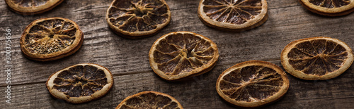 dried citrus slices on wooden brown surface, panoramic shot