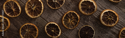 top view of dried citrus slices on wooden brown surface, panoramic shot
