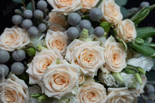 Beautiful wedding bouquet of bushy cream rose  eucalyptus  Brunei  Pittosporum and Lisianthus on a black background.
