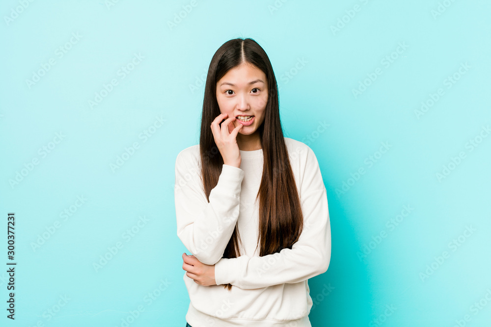 Young pretty chinese woman biting fingernails, nervous and very anxious. Young pretty chinese woman biting fingernails, nervous and very anxious.