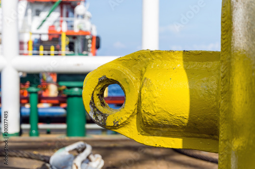 Lifting eye of a anchor buoy painted in yellow on board a constrcution barge at oil field photo