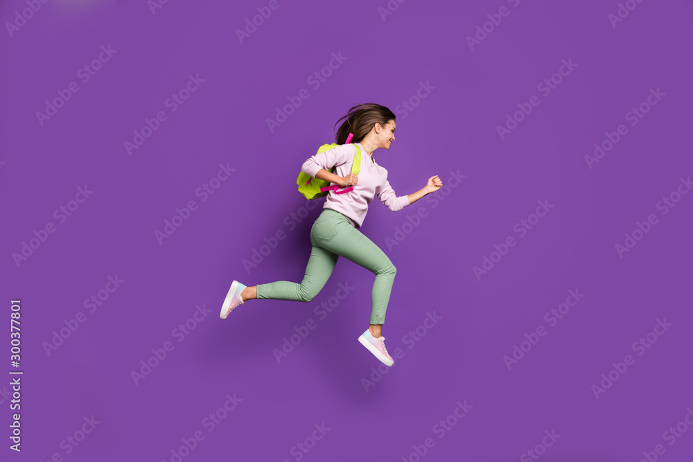 Full length body size profile side view of her she nice attractive lovely cheerful cheery girl jumping running high-school isolated on bright vivid shine vibrant purple violet lilac color background