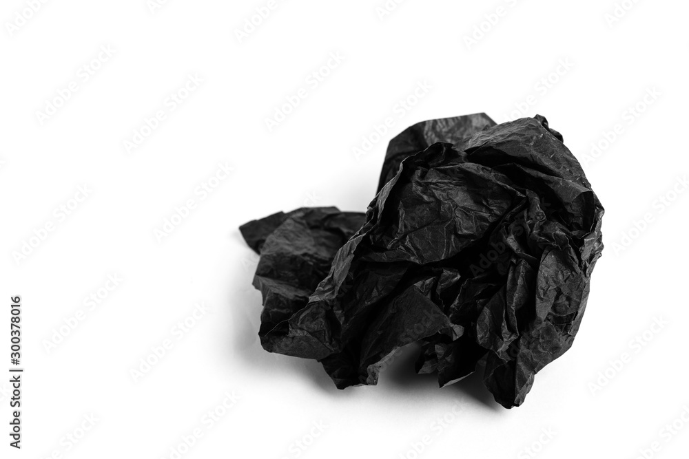 Crumpled sheet of black paper on a white background. Copy space.