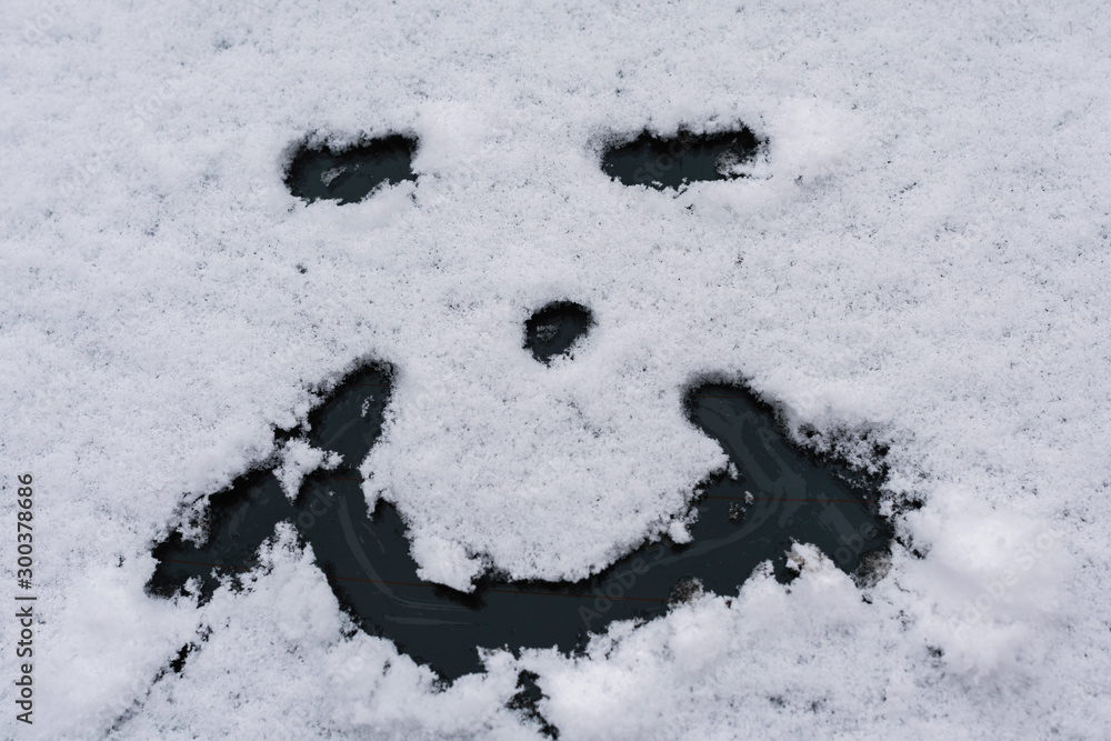 Fototapeta premium Snow happy face on the car window. Winter concept
