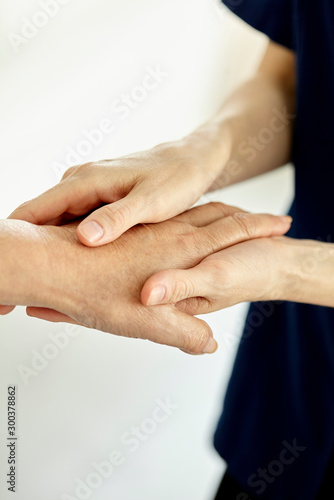 Close-up of nurse holding patient's hand photo