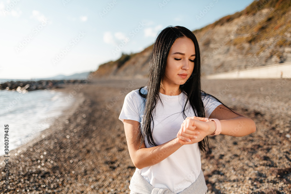 Sport. Young beautiful woman looks at her pocket watch while Jogging Sport. Young beautiful woman looks at her pocket watch while Jogging