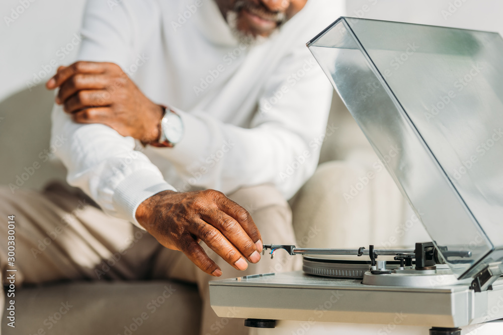 cropped view of african american man near record player cropped view of african american man near record player