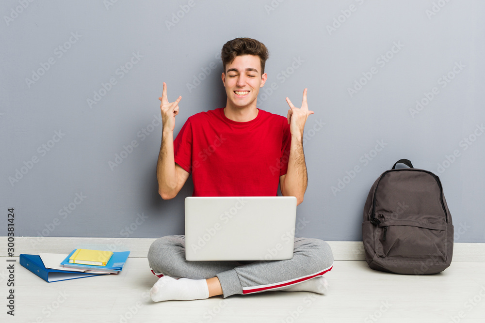 Young student man sitting on his house floor holding a laptop Young student man sitting on his house floor holding a laptop