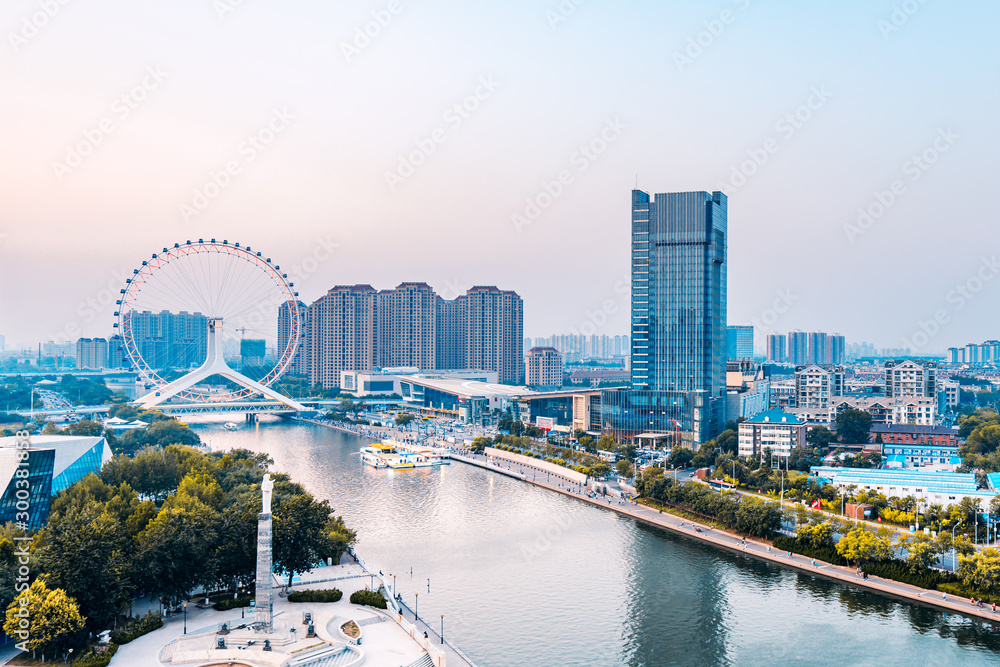 Naklejka premium Twilight scenery of Haihe River and Ferris wheel in Tianjin, China