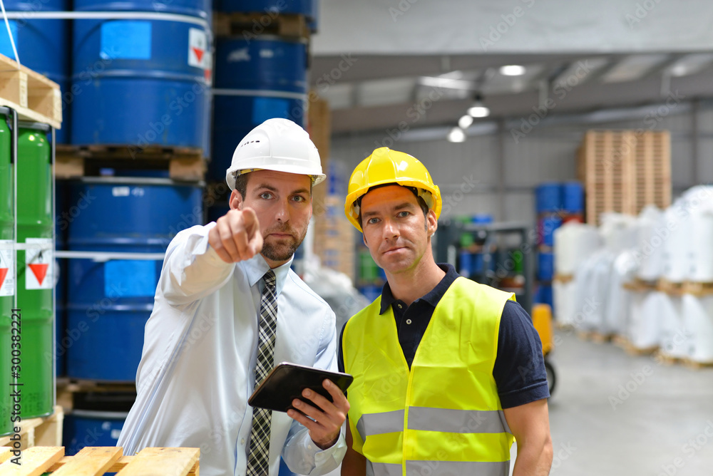 Teamwork: Arbeiter und Manager im Lager einer Gewerbeimmobilie - Workers in logistics Teamwork: Arbeiter und Manager im Lager einer Gewerbeimmobilie - Workers in logistics