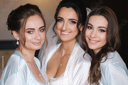 Close up portrait of charming bride with beautiful bridesmaids in blue negligee
