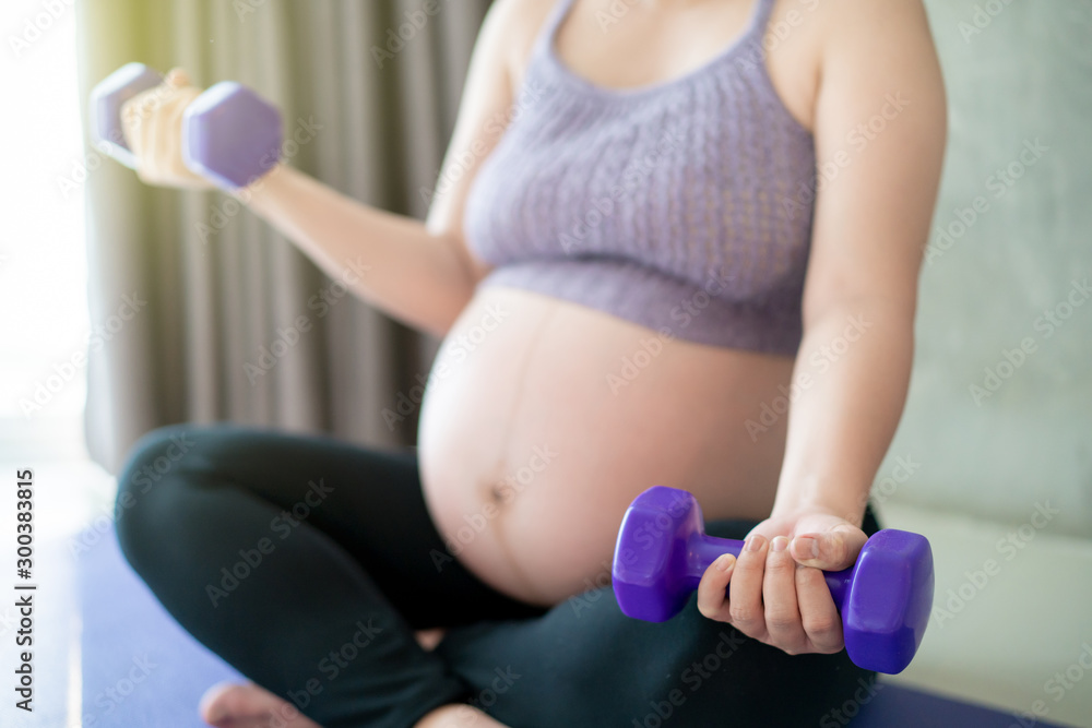 Good healthy pregnant woman doing weight exercise by using drumble. Healthy people and wellness concept. Good healthy pregnant woman doing weight exercise by using drumble. Healthy people and wellness concept.