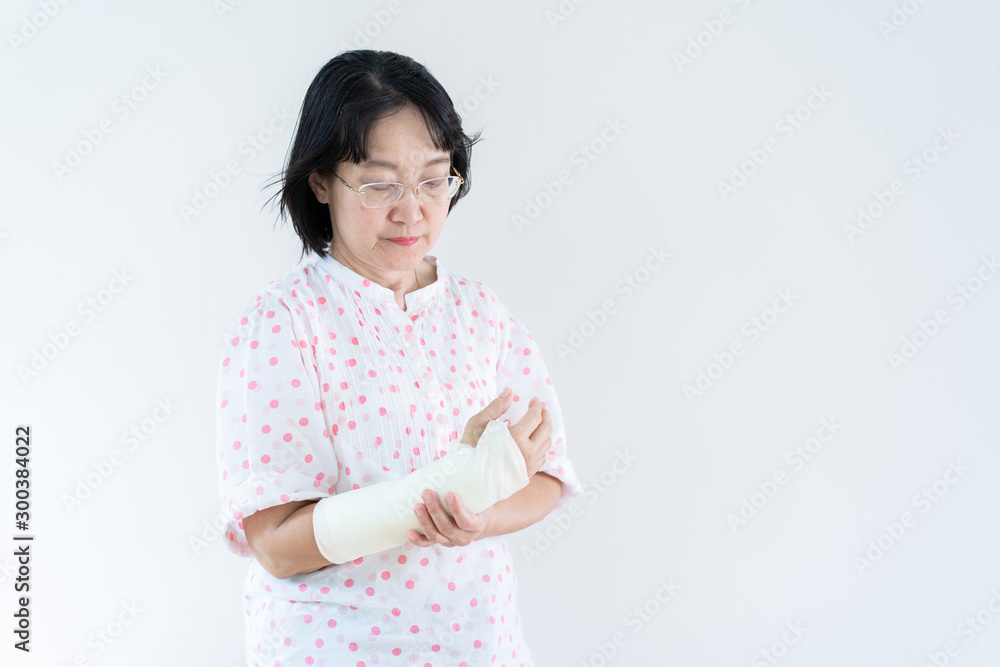 Adult Asian woman broken arm from accident, close up in half body with copy space. Concept of healthcare and aging society. Adult Asian woman broken arm from accident, close up in half body with copy space. Concept of healthcare and aging society.