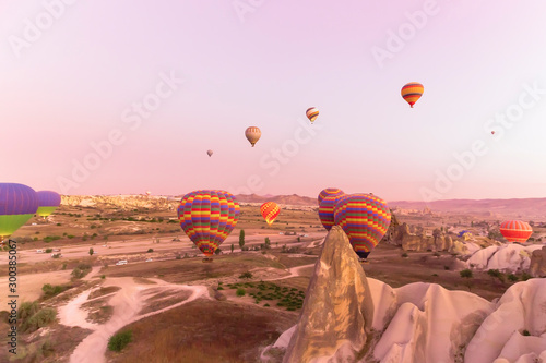 Pink sunrise in Cappodica with multicoloured hot air balloons
