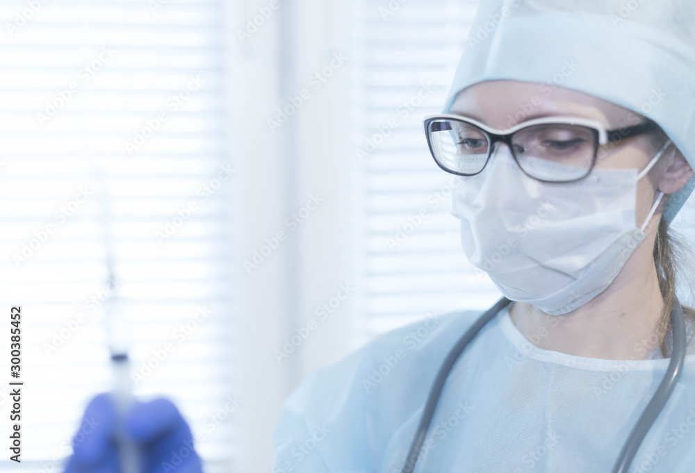 Medicine health background. Female doctor in mask and gloves holding a syringe with medicine, close-up Medicine health background. Female doctor in mask and gloves holding a syringe with medicine, close-up