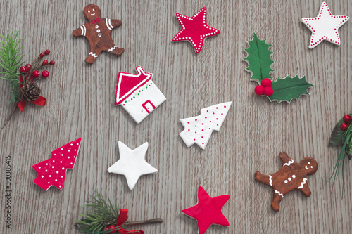 Christmas composition. Stars, gingerbread cookies, trees and green mistletoe on wooden background