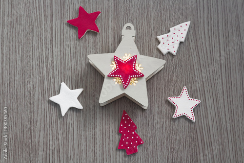 Christmas composition Red and white stars and trees on a wooden background