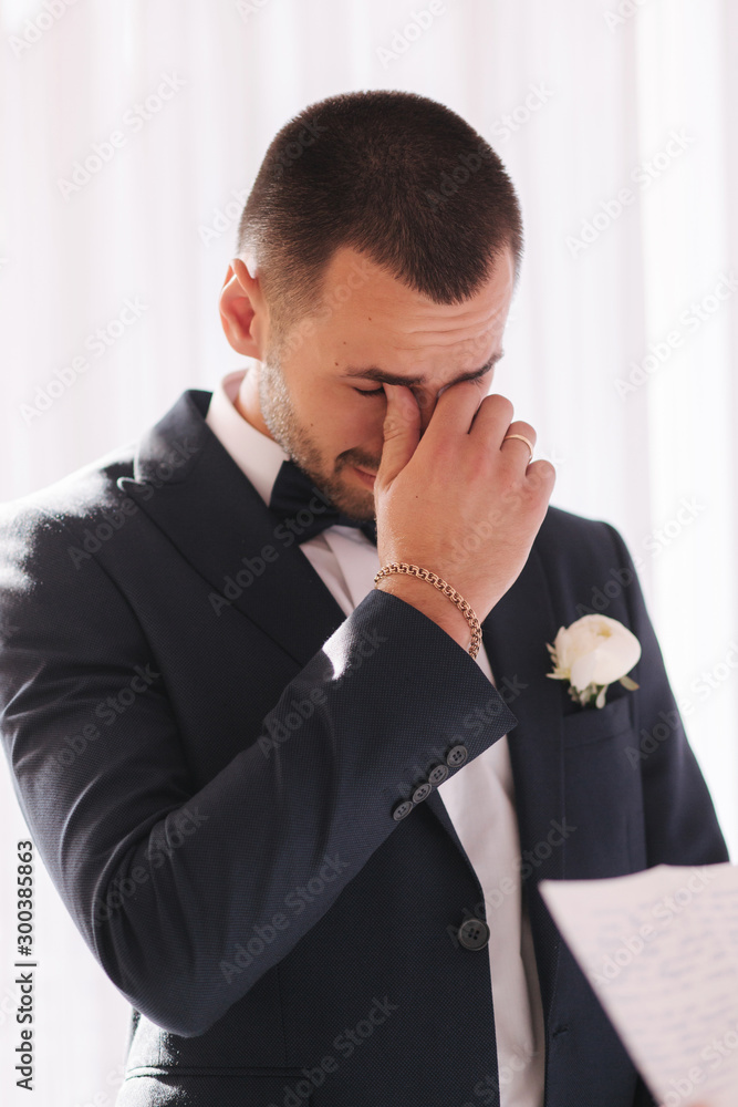 Handsome groom reading wedding vows and started crying. Groom have feeling of overwhelming love for bride Handsome groom reading wedding vows and started crying. Groom have feeling of overwhelming love for bride