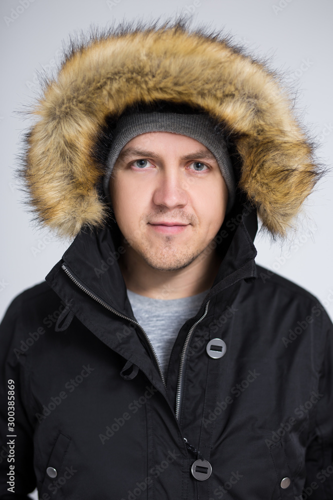 portrait of young handsome man in warm winter jacket over gray background portrait of young handsome man in warm winter jacket over gray background