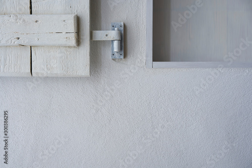 White wall with part of empty shelf and wooden shabby shutter © stock mp