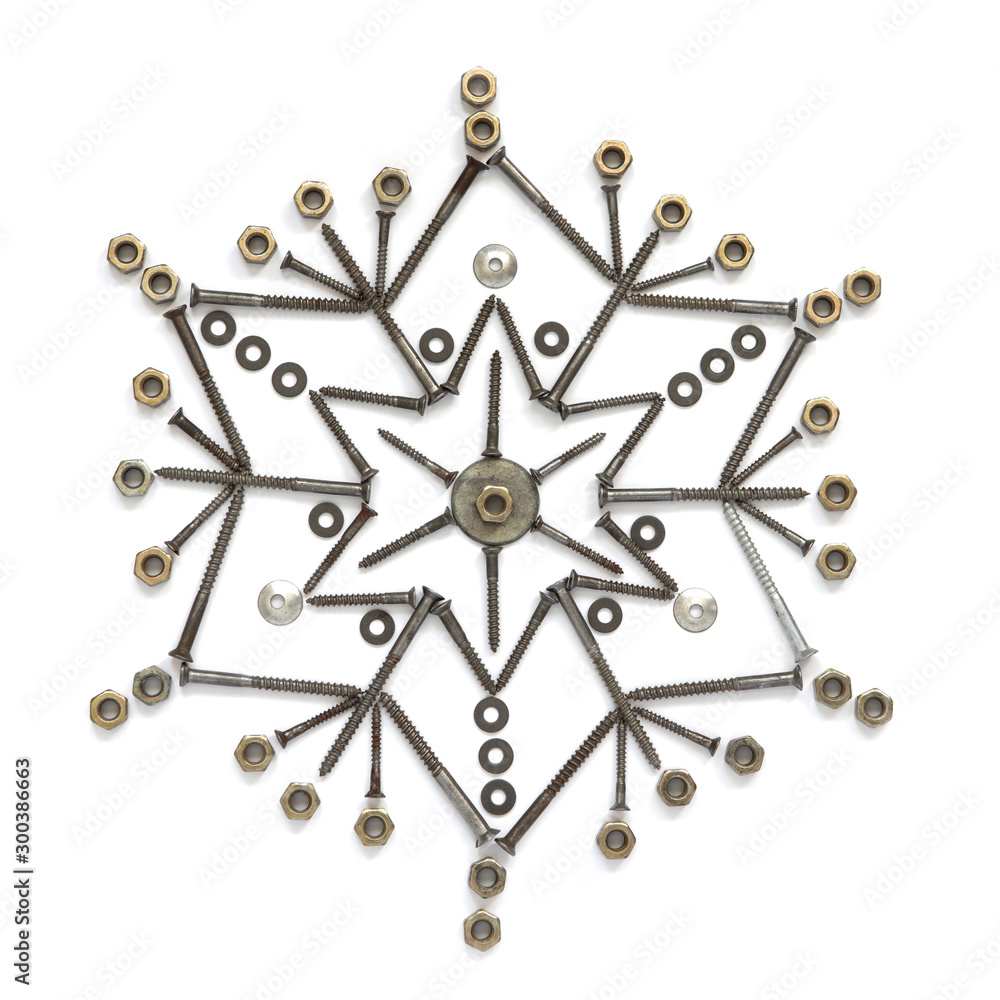 The snowflake of screws, washers, nuts on a white isolated background. View from above. Conceptual photography. The snowflake of screws, washers, nuts on a white isolated background. View from above. Conceptual photography.