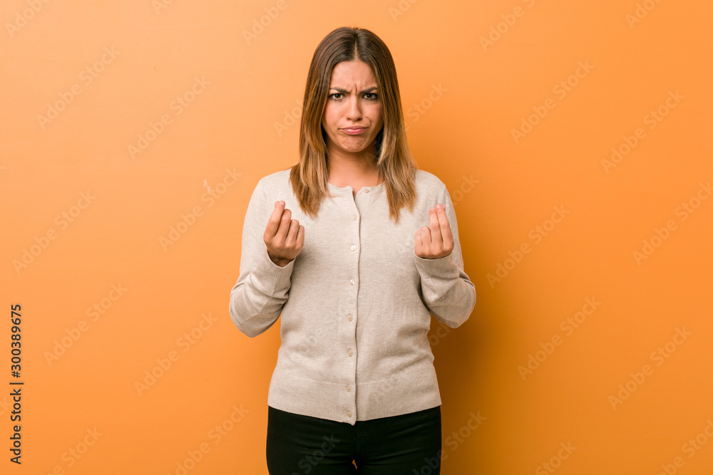 Young authentic charismatic real people woman against a wall showing that she has no money. Young authentic charismatic real people woman against a wall showing that she has no money.
