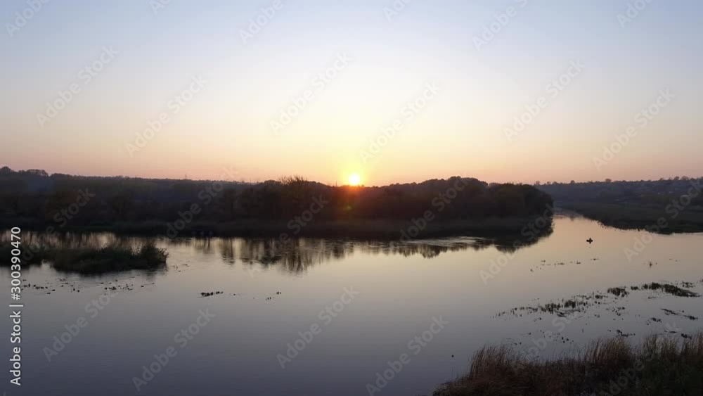 Aerial view autumn sunset over the river. Red sun. The camera moves in front. Aerial view autumn sunset over the river. Red sun. The camera moves in front.