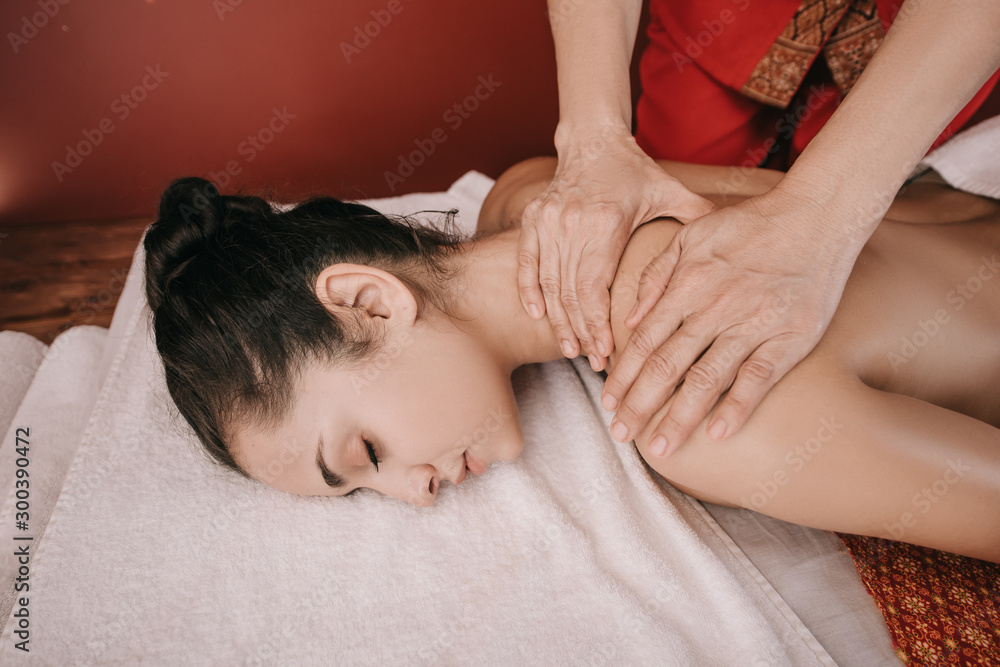 cropped view of masseur doing neck massage to woman in spa salon cropped view of masseur doing neck massage to woman in spa salon