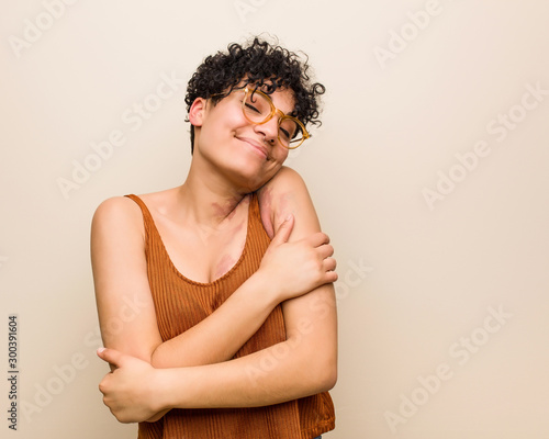 Young african american woman with skin birth mark hugs, smiling carefree and happy.
