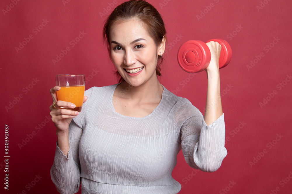 Young Asian woman with dumbbell drink orange juice. Young Asian woman with dumbbell drink orange juice.