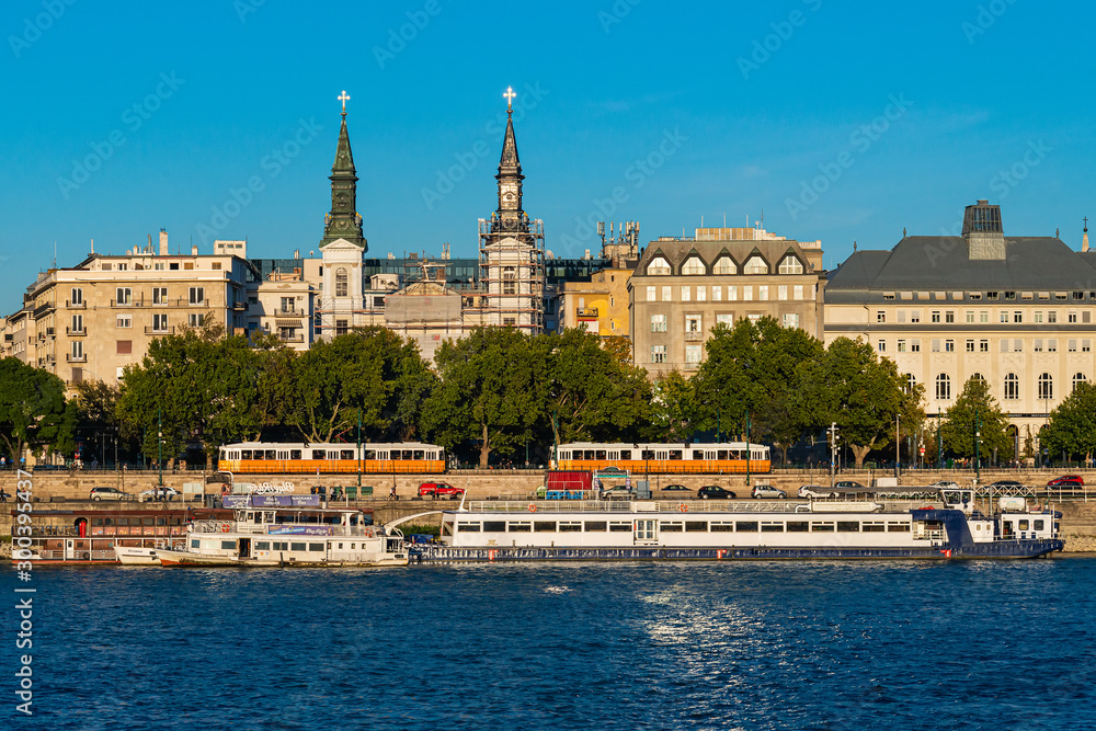 Budapest, Hungary - October 01, 2019: Cityscape of Budapest with Orthodox Cathedral of Our Lady with Budapest tram, passenger boats on the Danube river, Budapest, Hungary.