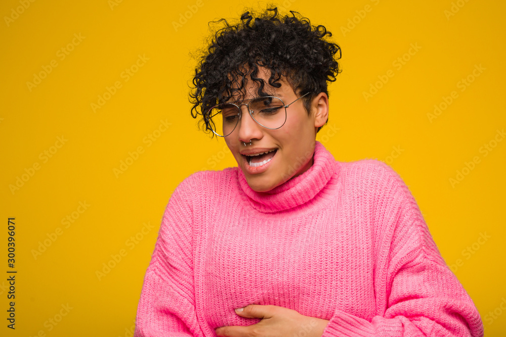 Young african american woman wearing a pink sweater sick, suffering from stomachache, painful disease concept. Young african american woman wearing a pink sweater sick, suffering from stomachache, painful disease concept.