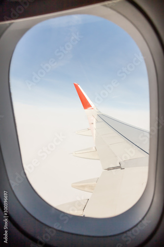 Looking through aircraft window airplane wing during flight