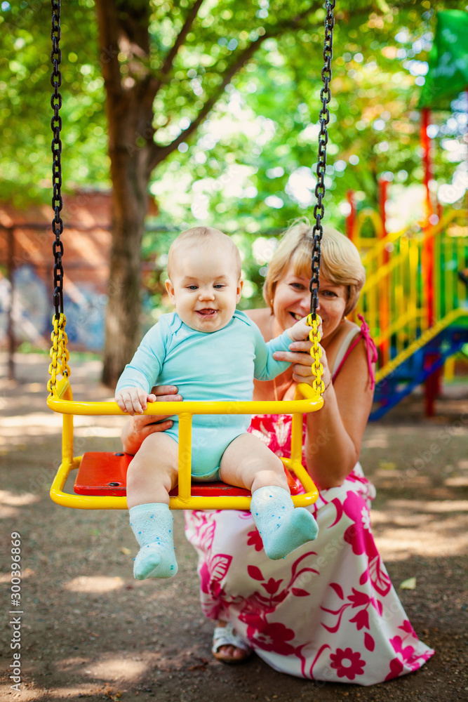 Loving mother hugs her little son in playground. Portrait of a beautiful mother with baby Loving mother hugs her little son in playground. Portrait of a beautiful mother with baby