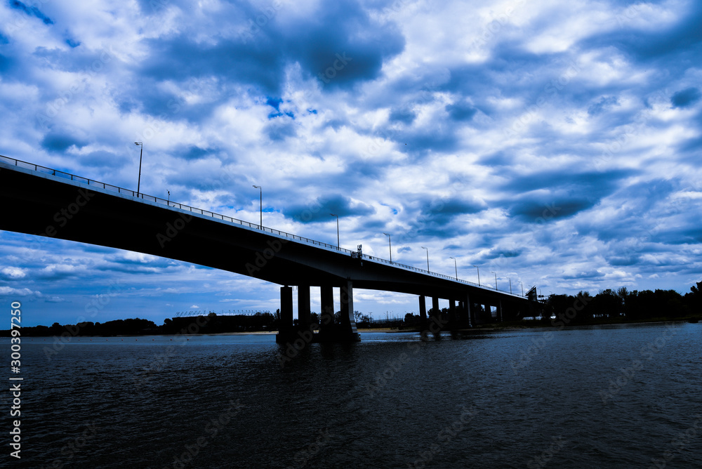 large road bridge over the river, contrasting clouds and blue sky, dramatic large road bridge over the river, contrasting clouds and blue sky, dramatic