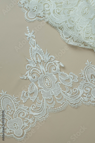 Texture lace fabric. lace on white background studio. thin fabric made of yarn or thread. a background image of ivory-colored lace cloth. White lace on beige background.