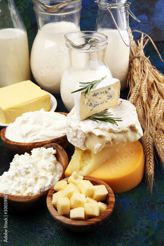Different healthy dairy products on rustic background with milk, cheese, butter and cottage