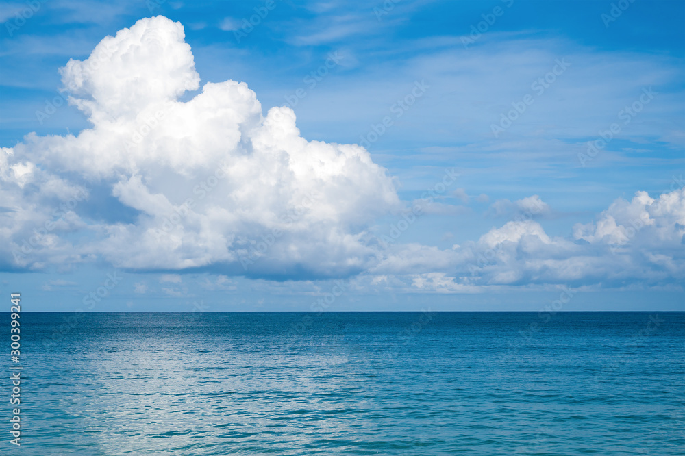 Seascape with a large white cloud on a blue sky. 