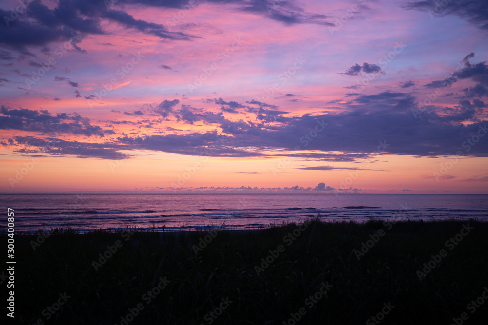 Obraz premium Cannon Beach at sunset: scenic orange, red and purple skies.
