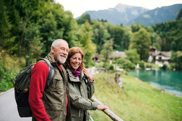 A senior pensioner couple hiking in nature, resting. Copy space.