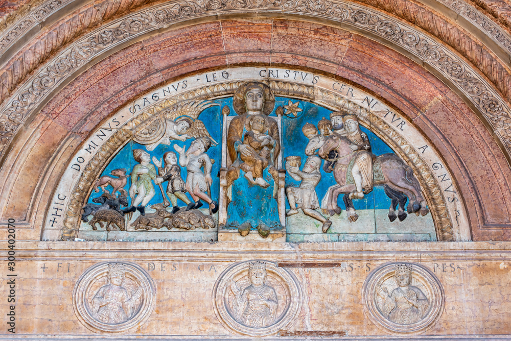 Colorful background with statues of catholic saints carved on church´s front door in Verona