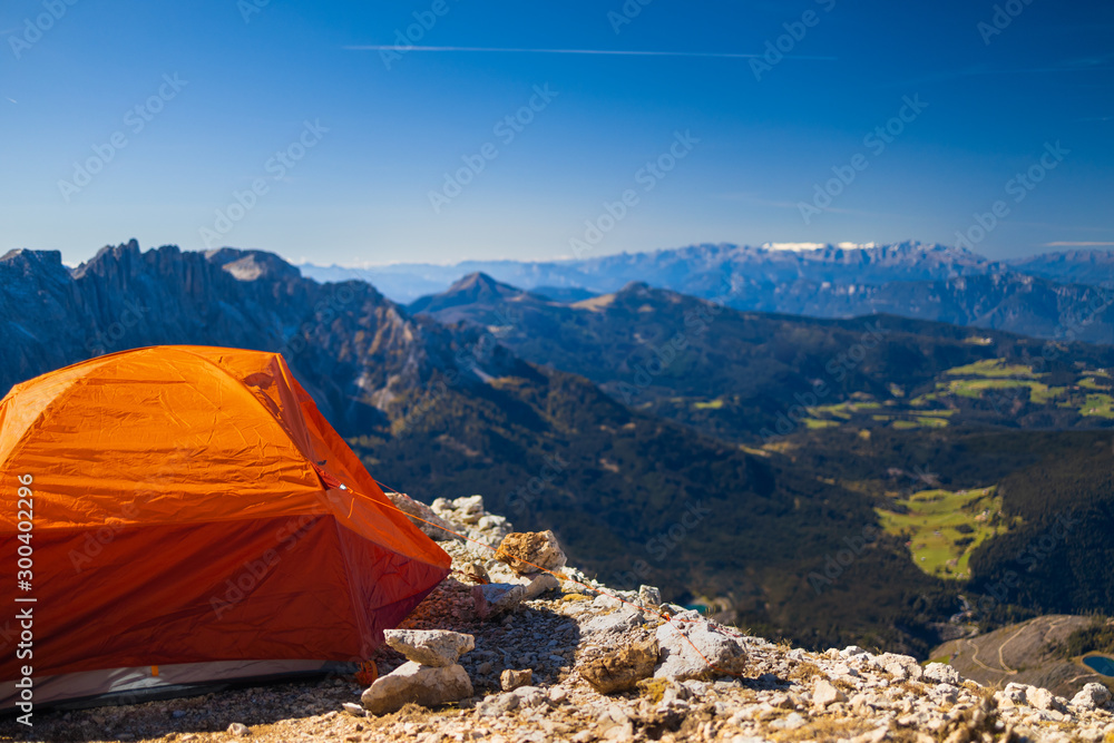 Beautiful alpine panorama with orange tent. Italian Alps