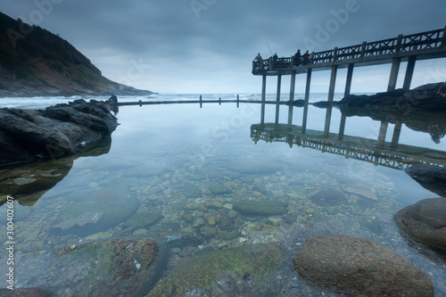 A stunning bay at dusk with fishermen on the pier