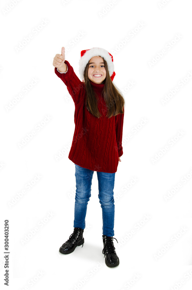 Full length of happy little girl in Santa hat showing ok sign isolated on white background Full length of happy little girl in Santa hat showing ok sign isolated on white background